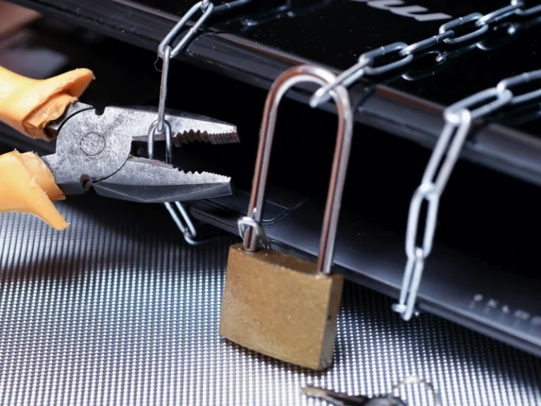 padlock holding a chain being broken with a pair of pliers